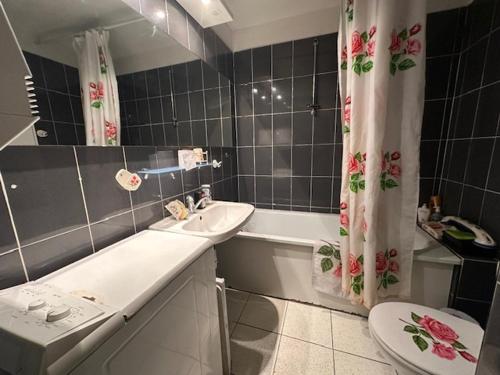 La salle de bains est pourvue d'un lavabo, de toilettes et d'un rideau de douche. dans l'établissement Appartement T3 Provençal avec Parking et Animaux admis, à 700m de la Plage - FR-1-799-54, au Barcarès