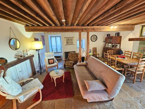 a living room with a couch and a table at L'Imprévu - Maison de vigneron à deux pas de Vézelay in Tharoiseau