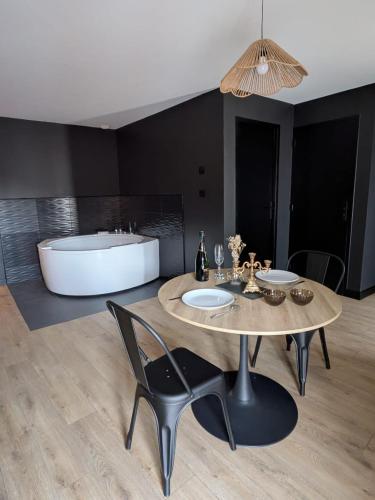 une salle à manger avec une table et une baignoire dans l'établissement jacuzzi, massage table, relaxation, wedding, loveroom, à Wizernes
