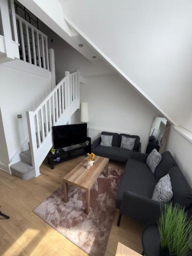 a living room with a couch and a table at Cosy 2 Bed Cardiff Bay Retreat! in Cardiff