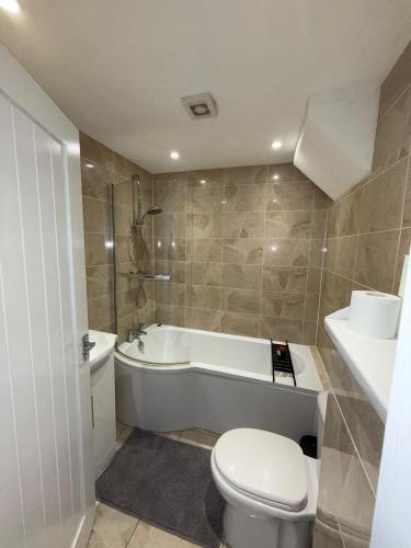 カーディフにあるCosy 2 Bed Cardiff Bay Retreat!のトイレ、浴槽、洗面台を備えたバスルーム