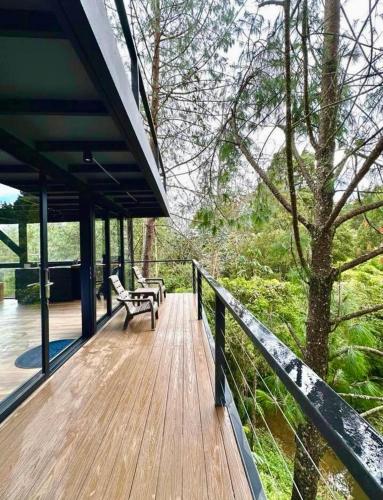 a wooden deck with a bench and a tree at 5 Continentes in Guarne