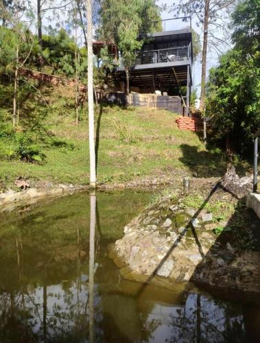a house on a hill next to a body of water at 5 Continentes in Guarne