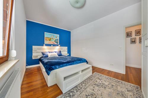 グダニスクにあるSailor House - Neptun Parkの青いアクセントの壁のベッドルーム1室、ベッド1台が備わります。
