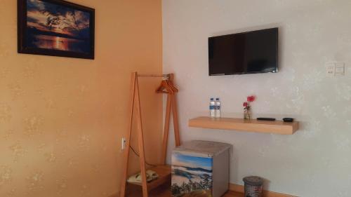 a corner of a room with a television on the wall at NEST House in Ấp Kim Thạch