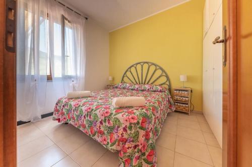 a bedroom with a bed with a floral bedspread and a window at Residence Vistamare La Fonte in Nisporto