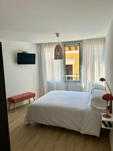 ein Schlafzimmer mit einem weißen Bett und einem Fenster in der Unterkunft BERENGUER HUESCA con parking in Huesca
