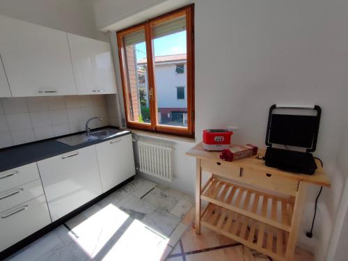 a kitchen with white cabinets and a sink and a window at Villa Luciana in Fano