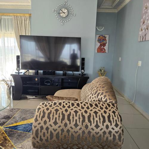 a living room with a large television and a chair at Cosy Villa in Stegi