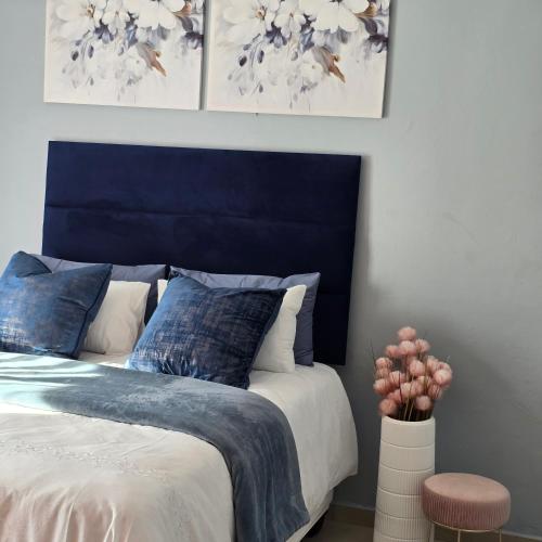 a bed with a blue headboard in a bedroom at Cosy Villa in Stegi