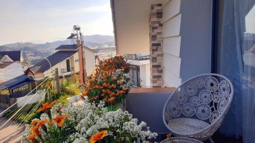 a balcony with a chair and flowers on a balcony at NEST House in Ấp Kim Thạch
