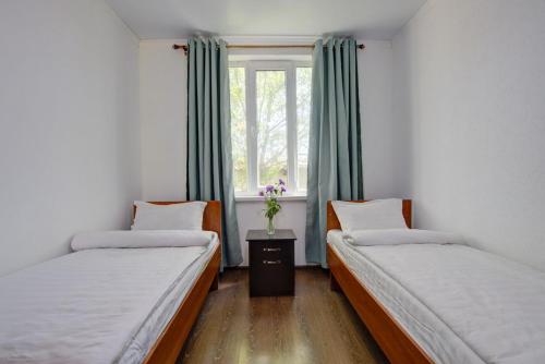two beds in a room with a window at Частный сектор in Bosteri
