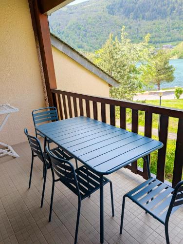 a blue table and chairs on a balcony with a view at Appt T3 calme bord du lac avec piscine in Loudenvielle