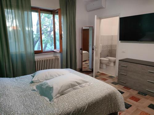a bedroom with a bed with a television and a bathroom at Villa Luciana in Fano