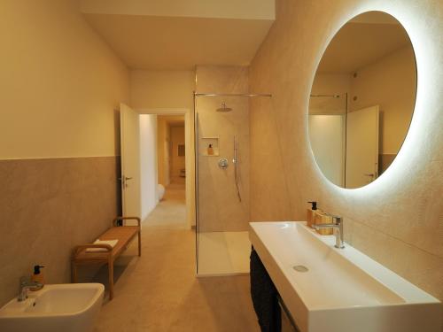 a bathroom with a sink and a mirror and a shower at Giselda Suite - Oval in Turin