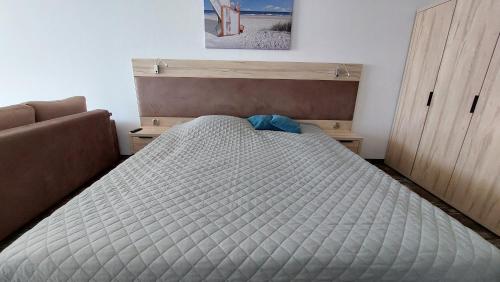 a bedroom with a bed and a couch at Apartament Sand Welle in Grzybowo