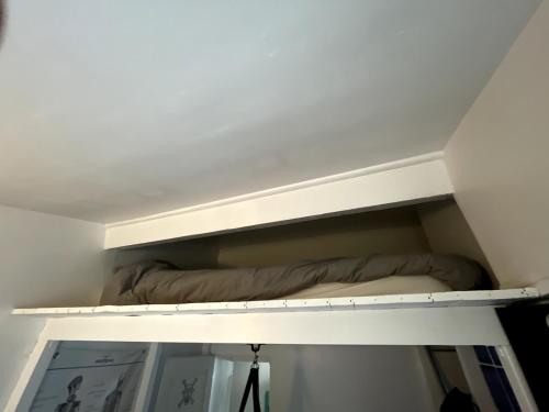 - une étagère dans une chambre avec un lit dans l'établissement Appartement Boutonnet Montpellier, à Montpellier