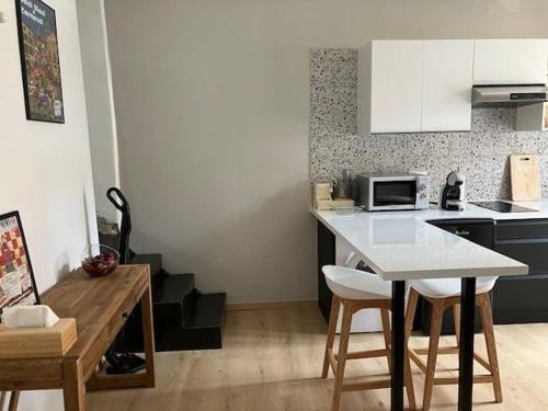une cuisine avec un comptoir et une table avec des chaises dans l'établissement Appartement Boutonnet Montpellier, à Montpellier