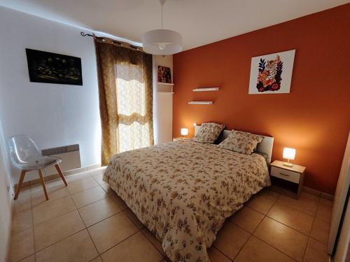 une chambre avec un lit avec un mur orange dans l'établissement Appartement T3 équipé idéal curiste avec parking, au Boulou