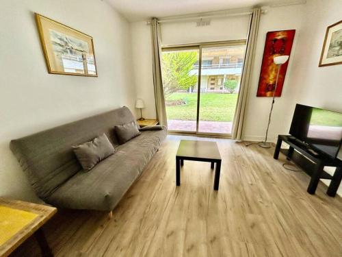 un salon avec un canapé et une table dans l'établissement The golden triangle Apartment, à Deauville