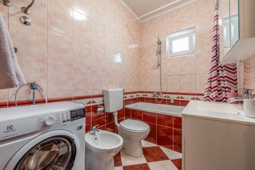 a bathroom with a toilet and a washing machine at Floyd in Bibinje