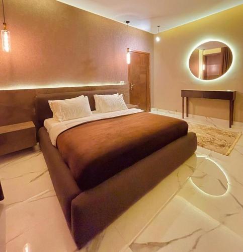 a large bed in a room with a mirror at Family Luxury Lodges in Islamabad