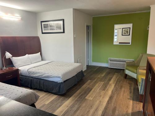 a hotel room with two beds and a chair at Travel In in Ridgeway
