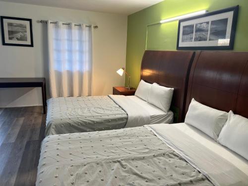 a hotel room with two beds and a window at Travel In in Ridgeway