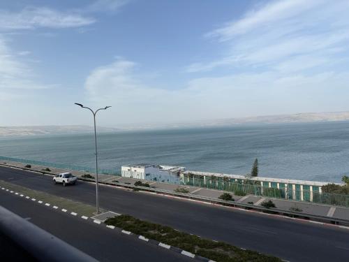 a view of a highway with a building and the ocean at לוי-קיישן מגוון דירות גן ופנטהאוזים וסוויטות נוף ברחוב הצנחנים in Tiberias