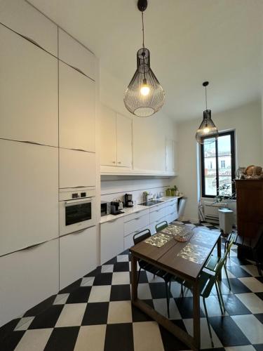 une cuisine avec des armoires blanches et une table dans l'établissement Les Floralies Chapitre Canebière, à Marseille