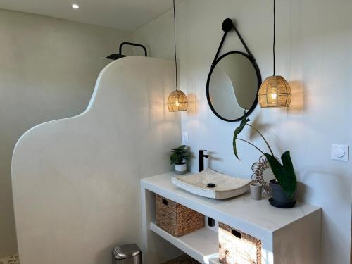 une salle de bain avec un lavabo et un miroir dans l'établissement Hippa, Cozy House, Wi-Fi, à La Jarne
