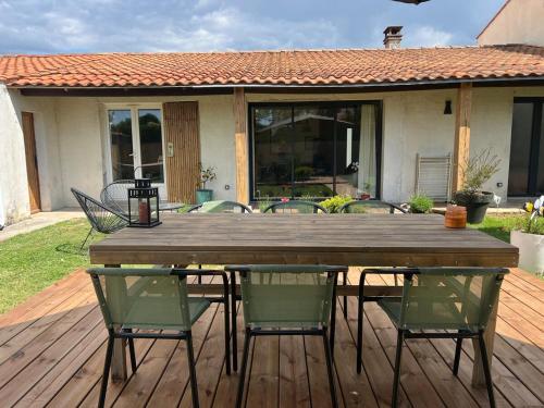 une table et des chaises en bois sur une terrasse dans l'établissement Hippa, Cozy House, Wi-Fi, à La Jarne
