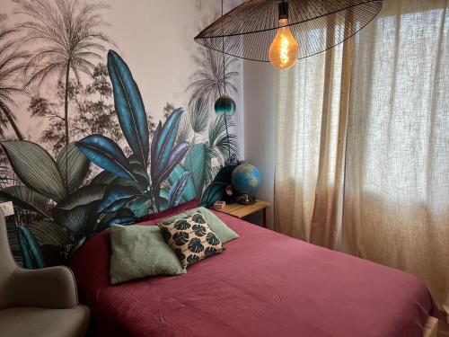 une chambre avec un lit rouge avec une plante dans l'établissement Hippa, Cozy House, Wi-Fi, à La Jarne