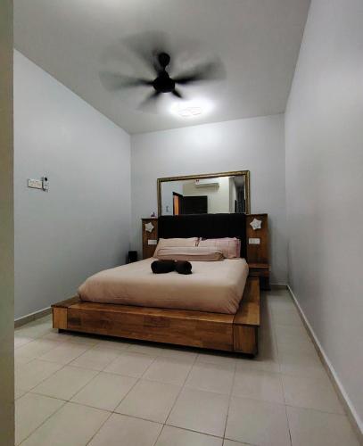 a bedroom with a bed with a ceiling fan at Homestay Naaila, Alor Gajah in Kampong Jelatang