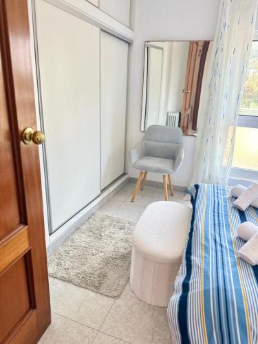 a bedroom with a bed and a chair and a window at Fantastic Seaview Apartment in Alicante