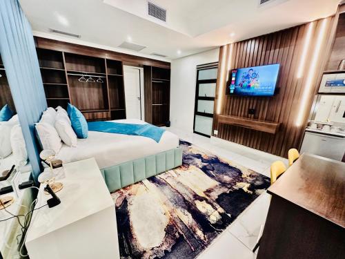 a hotel room with a bed and a flat screen tv at H & H Boutique & SPA in Roodepoort