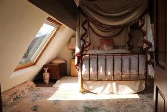 a bedroom with a canopy bed with a window at Parrs cottage in Wollaston
