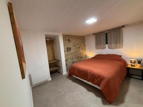 une chambre avec un lit et un mur de briques dans l'établissement Lesjolislogementsbrivistes exception, à Brive-la-Gaillarde
