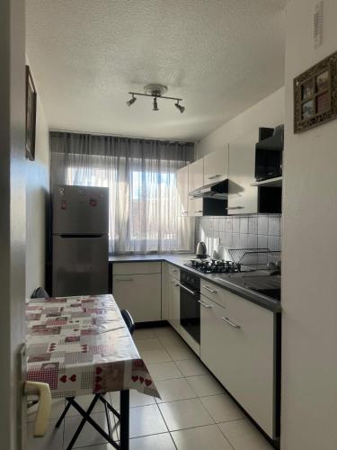 une cuisine avec un réfrigérateur et une table à l'intérieur dans l'établissement room in an apartment, à La Celle-sous-Gouzon
