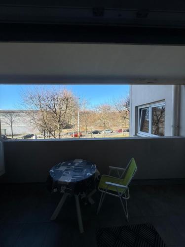 une table et une chaise dans une pièce avec une fenêtre dans l'établissement room in an apartment, à La Celle-sous-Gouzon