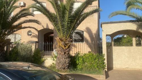 a palm tree in front of a building at Villa à louer nouaceur in Nouaseur