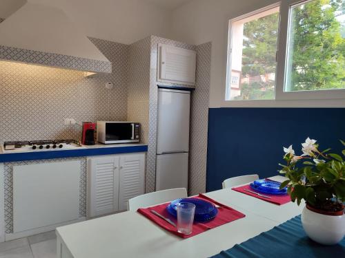 a kitchen with a table and a white refrigerator at Nest - Family House in Santa Flavia