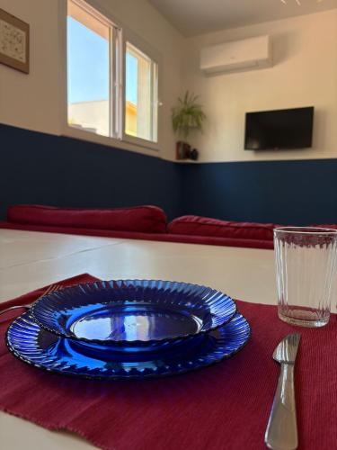 a blue plate sitting on top of a table at Nest - Family House in Santa Flavia
