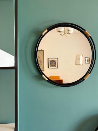 a mirror on a wall with a green wall at Nest - Family House in Santa Flavia