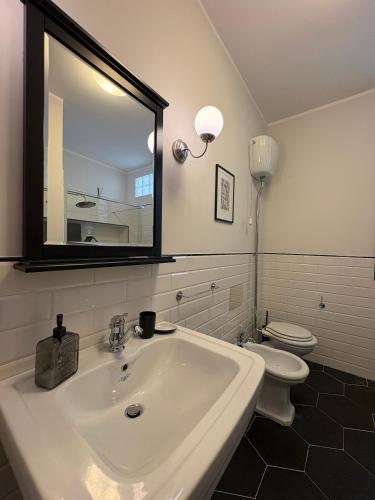 a bathroom with a white sink and a toilet at Nest - Family House in Santa Flavia
