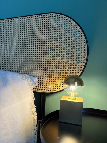 a lamp sitting on a table next to a bed at Nest - Family House in Santa Flavia
