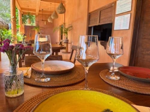 a table with three wine glasses on top of it at La Alberca Hotel Boutique in Mazunte