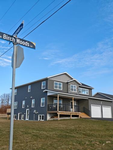 a house with a street sign in front of it at Birch Woods House in Stratford
