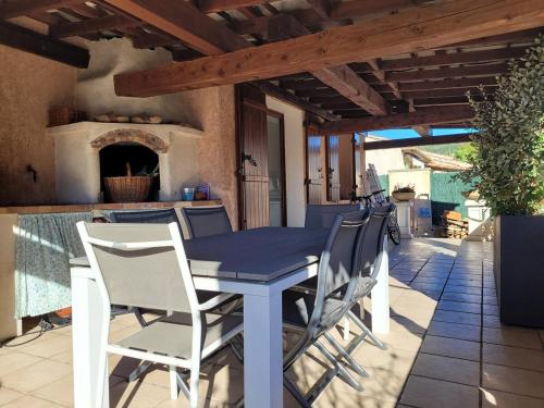 une table bleue et des chaises sur une terrasse avec une cheminée dans l'établissement Coquette maison 3 chambres, climatisée, à Grasse Côte d'Azur, à Grasse