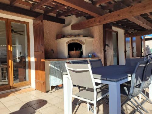 une table bleue et des chaises sur une terrasse avec une cheminée dans l'établissement Coquette maison 3 chambres, climatisée, à Grasse Côte d'Azur, à Grasse